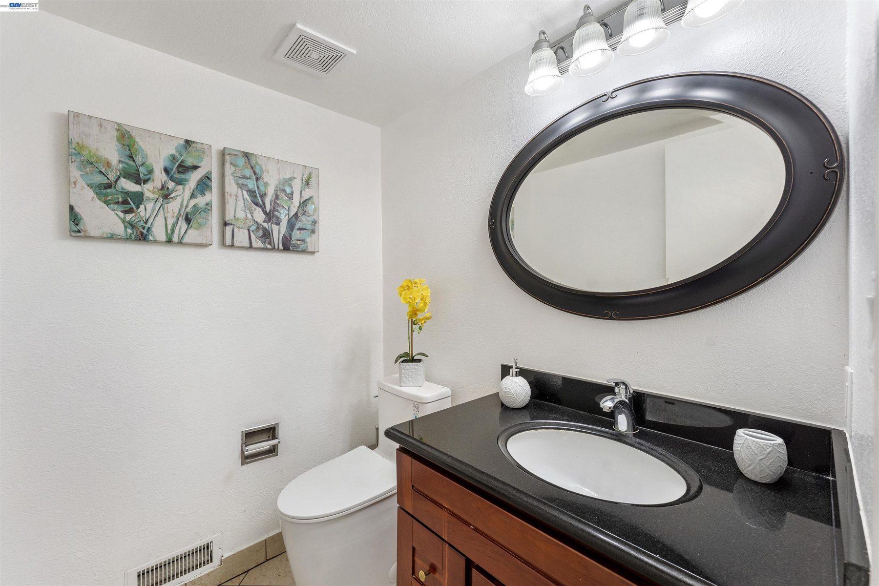 Bathroom with granite vanity and framed mirror